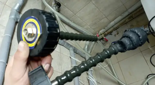 Przygotowanie do płukania instalacji centralnego ogrzewania. Wąż z przyłączem do pompy.