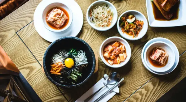Pyszne dania kuchni koreańskiej w qb restauracji: bibimbap, kimchi i łosoś.