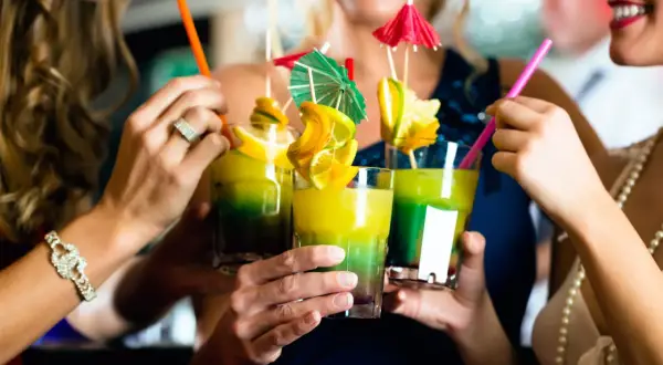 Amici brindano con cocktail colorati, un assaggio di divertimento nelle discoteche di Barceloneta.