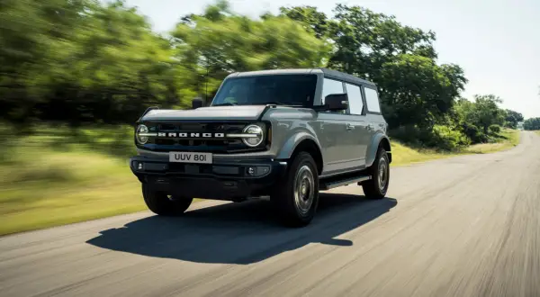 Grå Ford Bronco kör på en landsväg. Kolla in ford bronco pris för ditt nästa äventyr.