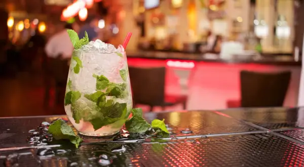 Orzeźwiający koktajl z rumem do mojito, lodem i miętą na barze.