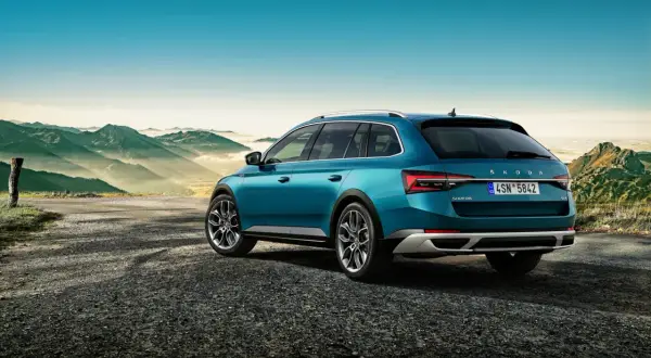 Turkusowy Skoda Combi na tle górskiego krajobrazu.