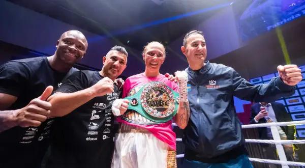 Patricia Berghult firar sin seger med sitt team, bärandes ett WBC-mästarbälte.