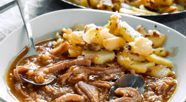 Herzhaftes Kutteln Rezept mit goldbraunen Bratkartoffeln, garniert mit Petersilie. Ein Löffel voller Genuss.