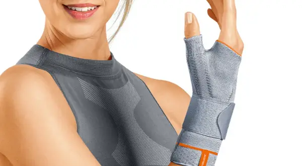 Frau mit Daumenbandage, die bei **arm verstaucht symptome** Linderung verschafft.