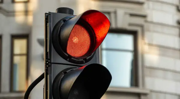 Un feu rouge clignote, signalant un danger. Le radar est prêt à flasher une fois.