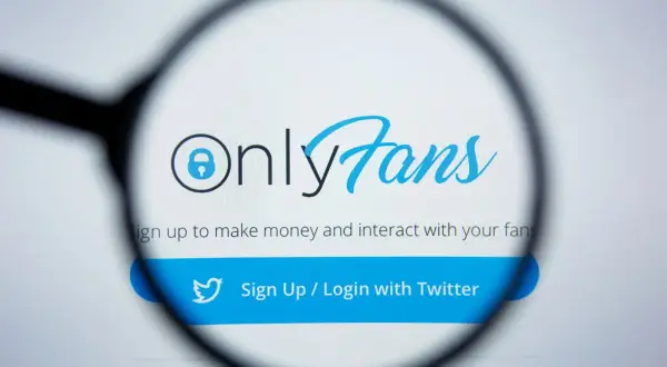 Logo OnlyFans pod lupą. Platforma pozwala zarabiać i wchodzić w interakcje z fanami. Dowiedz się, only fans o co chodzi.