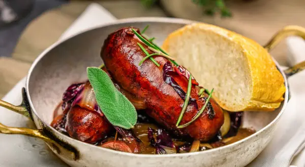 Eine herzhafte Salsiccia Wurst mit Rotkohl und Brot in einer Pfanne.