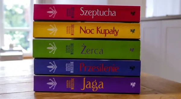 Pięć kolorowych książek Katarzyny Bereniki Miszczuk ułożonych jedna na drugiej. Na okładkach widnieje symbol kwiatu paproci.