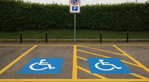 Due posti auto riservati con simbolo disabili. Attenzione: parcheggiare qui senza permesso comporta una multa per parcheggio invalidi.
