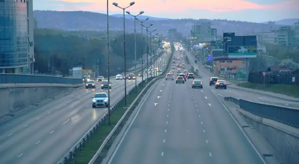 Ruch samochodowy na wielopasmowych autostradach i drogach ekspresowych o zmierzchu.