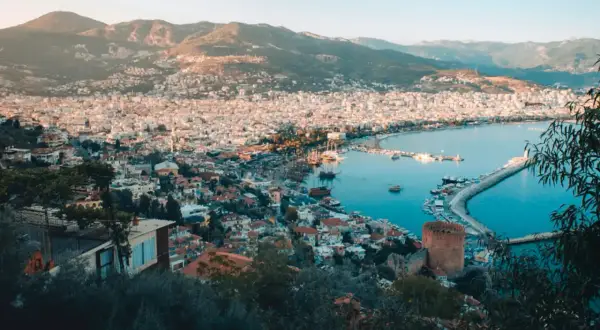Vy över Alanya med hamn, berg och stad. Perfekt för Alanya aktiviteter som båtturer och utforskning av historiska platser.