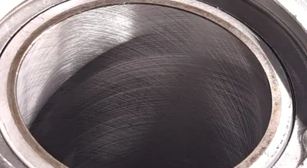 Metalowy cylinder z widocznymi śladami obróbki. Wnętrze, czyli big bore, jest ciemne i lekko błyszczące.