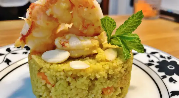 Un elegante cous cous gourmet con gamberi, mandorle e menta, un piatto raffinato.
