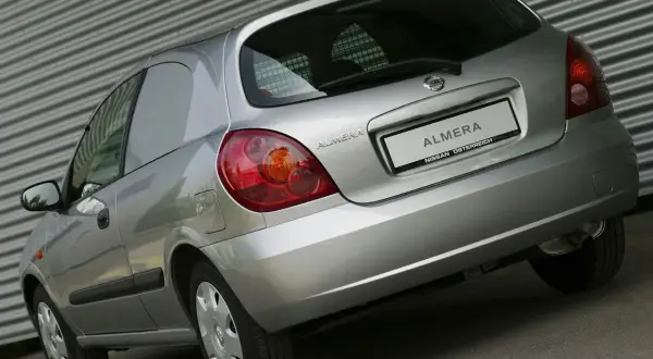 Srebrny Nissan Almera N16 z tyłu, z widocznym napisem "ALMERA NISSAN ÖSTERREICH" na klapie bagażnika.