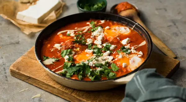 En smakrik shakshuka med ägg, tomat och fetaost, perfekt för en mysig frukost eller brunch.