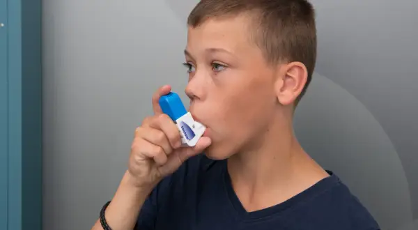 Pojke använder inhalator. Tänk på att vape farligt kan påverka lungorna.