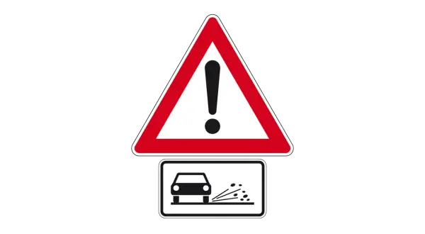 Achtung! Zeichen 265 warnt vor Steinschlag. Ein Auto fährt über lose Steine, die aufgewirbelt werden.