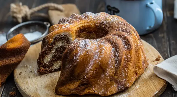 Pyszna babka piaskowa dwukolorowa, oprószona cukrem pudrem, czeka na kawę.