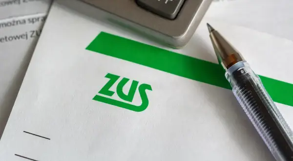 Długopis i kalkulator na dokumencie z logo ZUS.