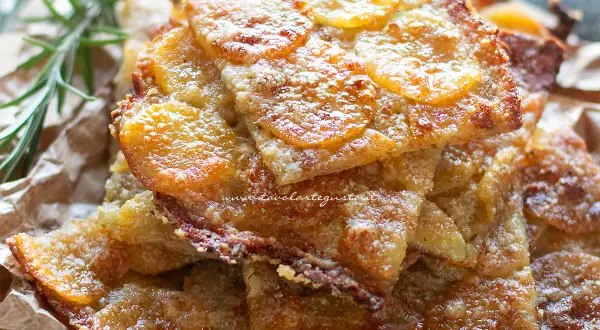 Schiacciata di patate dorata e croccante, con fette sottili di patate e un tocco di rosmarino.