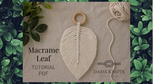 Décoration murale en macramé aux couleurs vives, avec des cordes torsadées formant des feuilles.