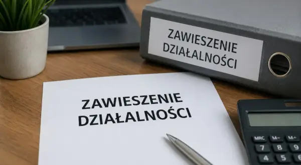 Dokumenty dotyczące zawieszenia działalności i ZUS leżą na biurku obok kalkulatora i laptopa.