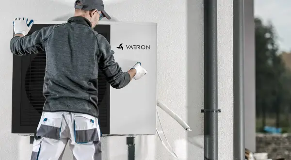 Técnico revisa unidad de aerotermia Vaeron, asegurando el correcto desescarche para óptimo funcionamiento.
