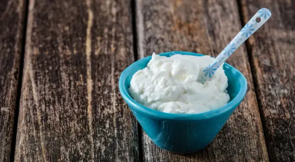 Ein blauer Napf mit cremigem Skyr oder Magerquark, bereit zum Genuss.