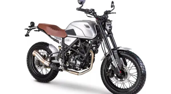 Srebrny Romet Scrambler 125 z brązowym siedzeniem i oponami terenowymi, gotowy na przygodę.