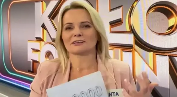 Kobieta z Koła Fortuny trzyma kartę z napisem "00000", zastanawiając się, co daje złota karta w kole fortuny.