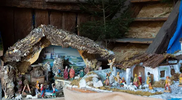 Dettaglio di presepi italiani con figure sacre, pastori e animali, ambientati in un paesaggio stilizzato.