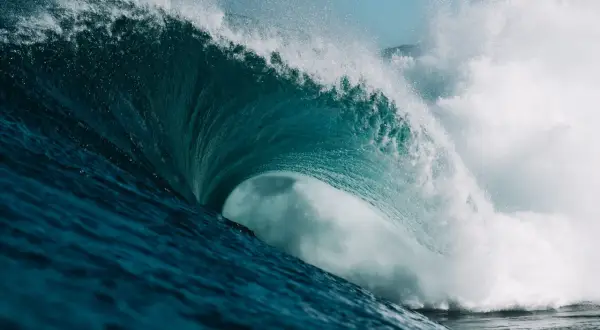 Eine gewaltige Welle bricht, ihr türkises Wasser schäumt. Wie die neuesten ocean protocol news, die sich schnell verbreiten.