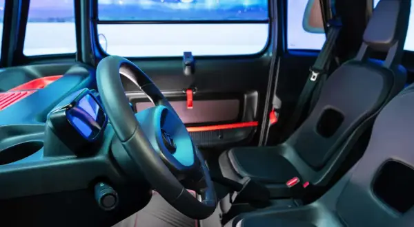 Interni Citroën Ami: volante, sedili neri e un display blu. Un'atmosfera futuristica per la mobilità urbana.