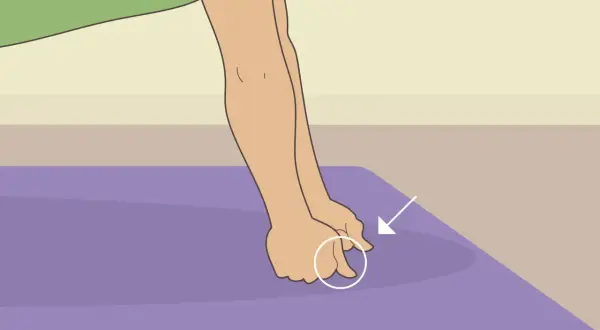 Close-up of hands performing a hand conditioning exercise on a purple mat, with an arrow pointing to the fingers.