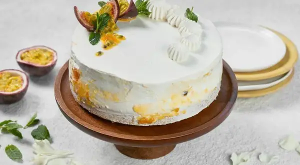 En vacker vegansk tårta med passionsfrukt och mynta, dekorerad med små maränger.