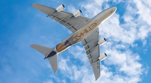 Ein Airbus A380 von Etihad Airways fliegt unter blauem Himmel mit Wolken. Diese Fluggesellschaft gehört zu den 60 sichersten Fluggesellschaften der Welt.