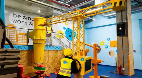 Dzieci budują na Smart Kids Planet w Warszawie. Żuraw i wózek budowlany czekają na małych inżynierów.