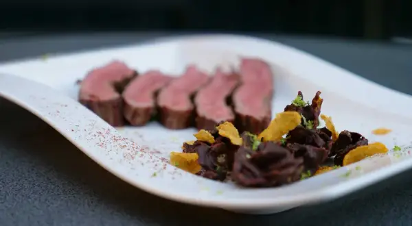 Saftiges Flank Steak, in Scheiben geschnitten, serviert mit dunkler Schokolade und knusprigen Chips.