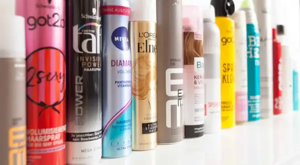 Reihe von Haarspray-Dosen, darunter "got2b 2sexy" und "NIVEA DIAMANT", ideal für Haarspray auf nasse Haare.