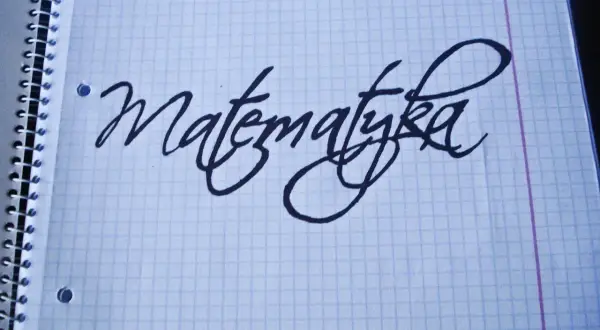 Napis "Matematyka" wykonany ozdobnym pismem odręcznym na kartce w kratkę.