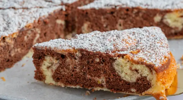 Ein saftiger Marmorkuchen, perfekt für jedes wolkenkuchen rezept. Mit Puderzucker bestäubt und bereit zum Genießen.