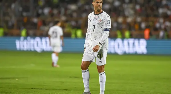 Cristiano Ronaldo w białej koszulce z numerem 7 na boisku piłkarskim.