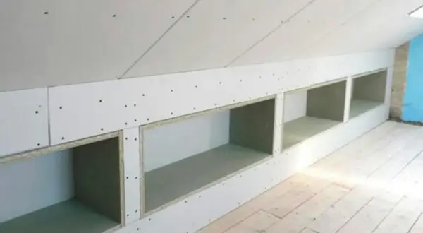 Zabudowa skosów na poddaszu z otwartymi wnękami, idealna na półki.