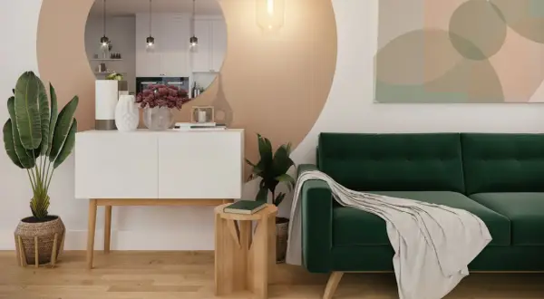 Sofá verde esmeralda y plantas crean una atmósfera de serenidad. La decoración verde aporta vida a este espacio moderno.