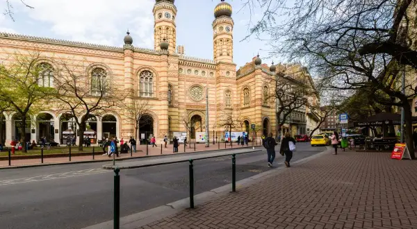 Stora synagogan i Budapest, ett landmärke i de judiska kvarteren, med folk som promenerar på trottoaren.