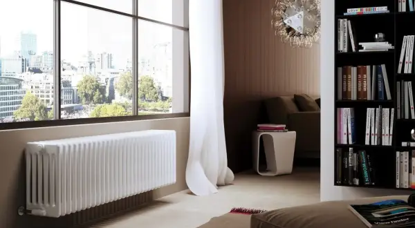 Un elegante termosifone bianco sotto una grande finestra con vista sulla città.