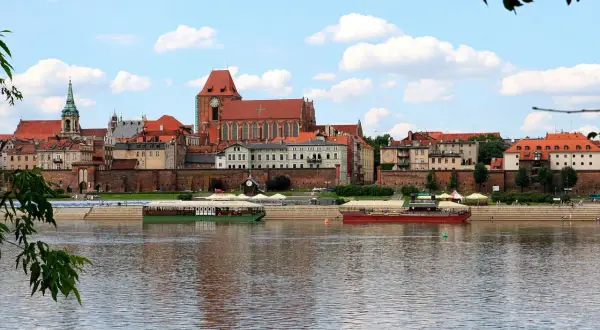 Widok na zabytkowe Stare Miasto Toruń z Wisłą i statkami wycieczkowymi. Tak wygląda Toruń.