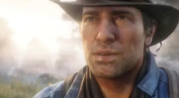 Arthur Morgan w kapeluszu i dżinsowej koszuli, zamyślony, na tle mglistego krajobrazu.