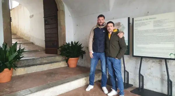 Due amici sorridono davanti al Santuario di San Patrizio, un luogo storico.